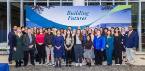 Image of large group of employees and students in front of "Building Futures" banner. 