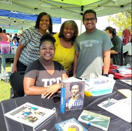 Students and staff at activities fair table.