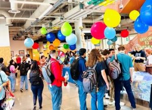 Students at activities fiar with colorful balloons.
