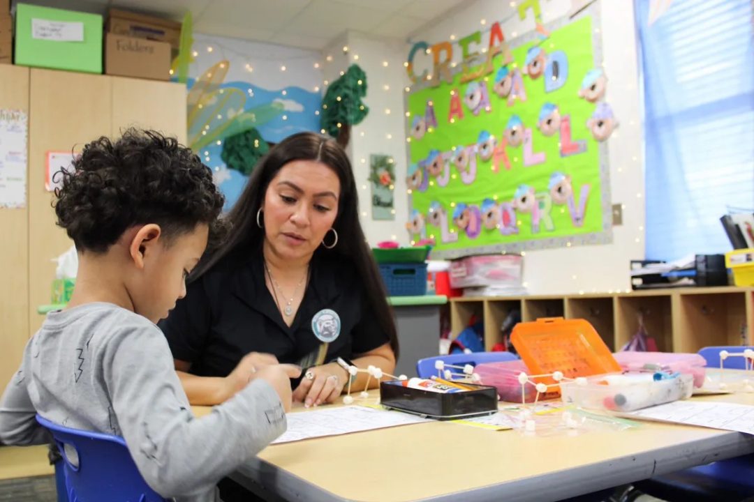 Teaching assistant Marissa Garcia shows students how to complete a math assignment Feb. 12, 2024, at McNutt Elementary. The elementary school offers a pre-K program, a driving factor to attract more students to the district