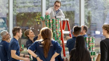 GE Aerospace employees work with TCC students at TCC Trinity River to build structures out of donated canned food.